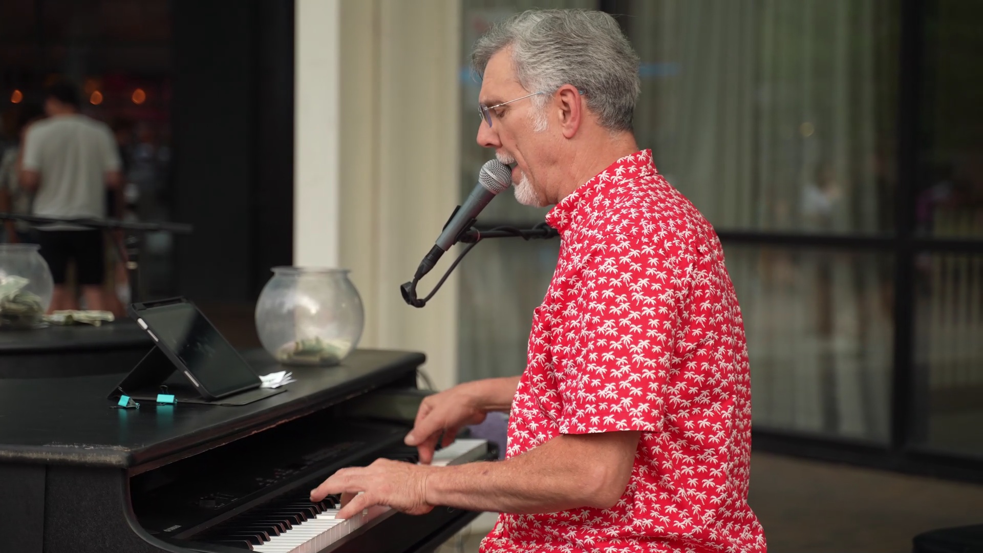Midwest Dueling Pianos performer in a red patterned shirt singing and playing piano.